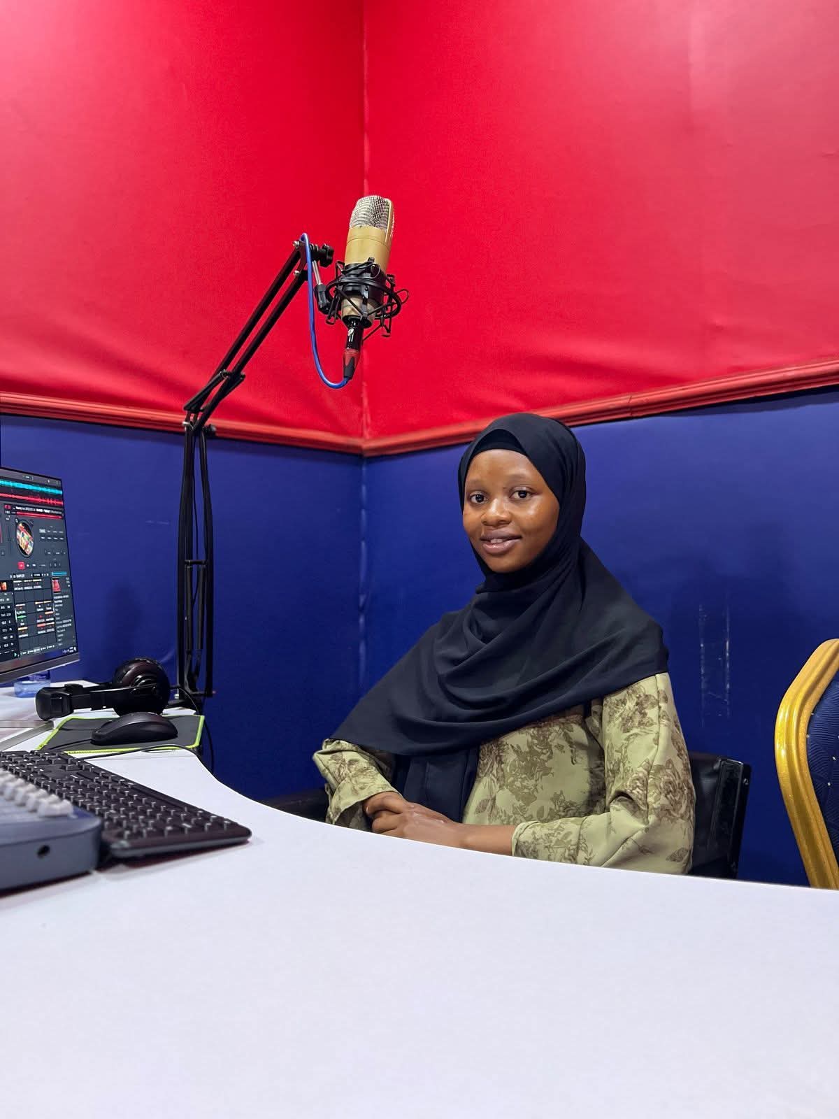 Presenter seated at the JAC FM studio microphone