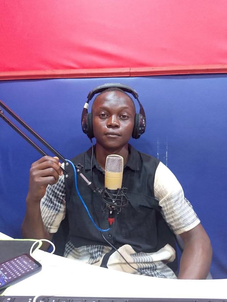Young presenter adjusting the mic arm in the JAC FM studio